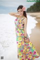 A woman in a colorful dress standing on a beach.