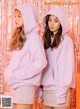 two girls in pink hoodies standing next to each other