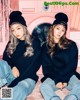 two girls sitting next to each other in front of a washing machine