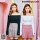 two girls standing next to each other in front of a pink wall