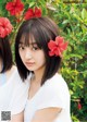 A woman with a flower in her hair standing next to another woman.