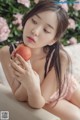 A woman sitting on a couch holding an apple.