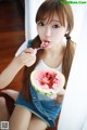 A young woman eating a slice of watermelon with a spoon.