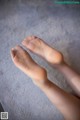 A close up of a person's bare feet on a carpet.