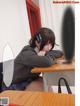 A woman sitting at a desk with her head on her hand.