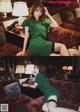 A woman in a green dress sitting on a couch.