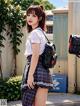 A woman in a school uniform is posing for a picture.