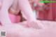 A woman in white tights and pink ballet shoes on a pink carpet.