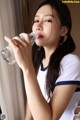 A woman drinking water from a bottle of water.