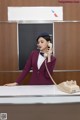 A woman in a business suit talking on a telephone.