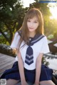 A woman in a school uniform sitting on a dock.