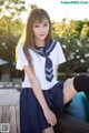 A woman in a sailor outfit sitting on a chair.