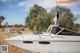 A woman sitting on top of a boat in the desert.