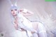 A woman in a white bunny costume posing for a picture.